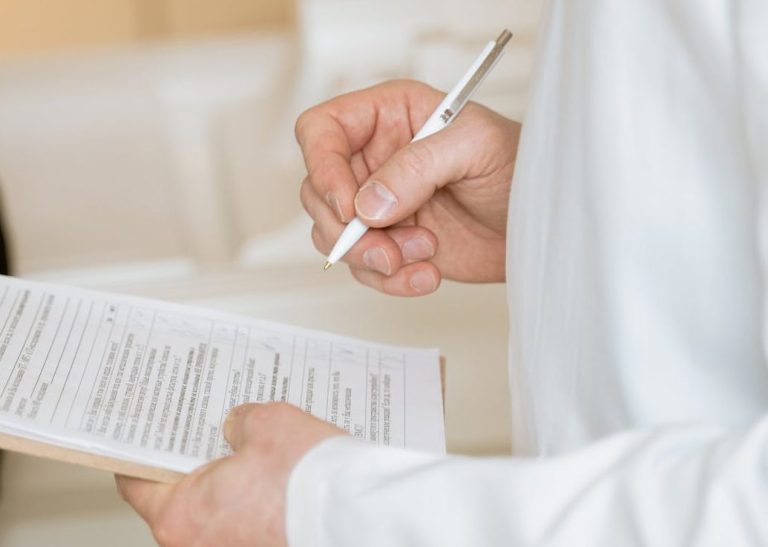 Med. Gutachter schreibt auf Klemmbrett